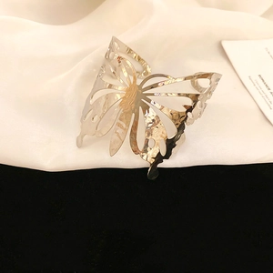 Close-up of hollow butterfly cuff bracelet with hammered metal texture and silver finish