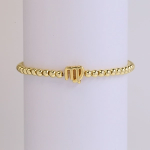 18k gold plated Virgo zodiac charm beaded elastic bracelet shown on a white display stand