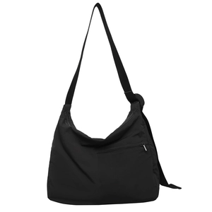 Minimalist black nylon crossbody bag with large capacity and adjustable strap on white background