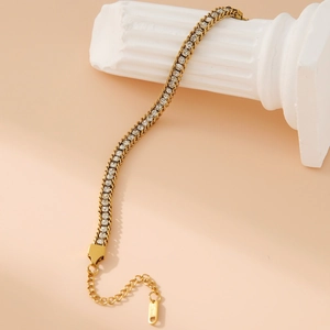Elegant gold tennis bracelet with shimmering round zircons on a white pillar display