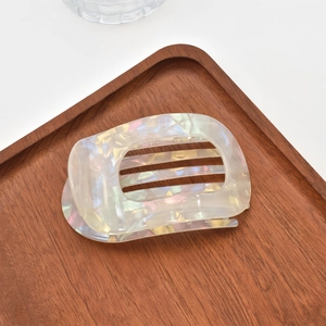 Close-up of a pearlescent white acetate hair claw clip with a hollow circular design