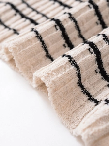 Makroaufnahme von dickem cremefarbenem Strickstoff mit schwarzen Streifen Textur