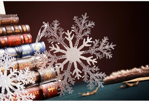 Detailed macro view of a large clear acrylic snowflake pendant with white ribbon hanging