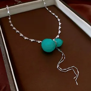 Silver heart chain necklace with green gourd pendant and metallic tassels in Chinese style