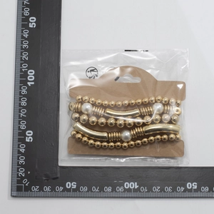 Detail view of multi-layer beaded bracelet set with gold beads and faux pearls