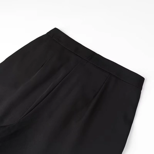 Detailed view of black waistband stitching and smooth draping fabric texture