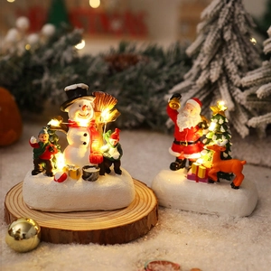 Detail of glowing resin Christmas figurines with LED lights on a rustic wood base