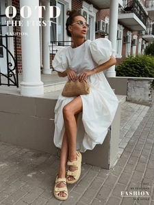 Détail d'une robe en coton blanc à manches bouffantes avec des accessoires de paille d'été