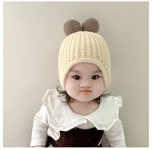 Detail of baby knitted earflap hat with double brown bows and soft ribbed texture