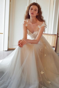 Détail de la robe de mariée en tulle ivoire avec appliques papillon 3D et décolleté en V