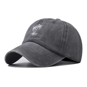 Close-up of white coconut tree embroidery on a vintage washed dark grey baseball cap