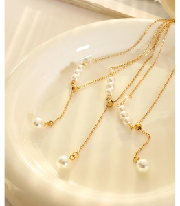 Detail of French style faux pearl necklace with gold beads and large pearl pendants