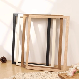 Minimalist solid wood picture frames in four colors displayed on a natural wooden table