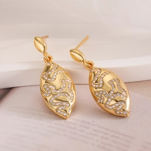 Detail of gold teardrop earrings featuring intricate cubic zirconia pave patterns