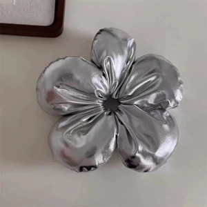 Detail of silver metallic flower hair scrunchie showing the soft reflective fabric texture