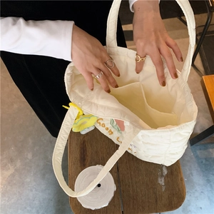 Close-up of quilted tote bag interior with large storage compartment and embroidery