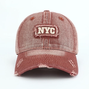 Close-up of vintage red NYC baseball cap with 3D embroidery and distressed ripped details