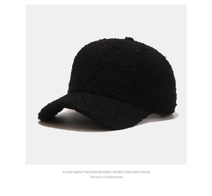 Close-up of thick black faux shearling texture on a warm winter baseball cap