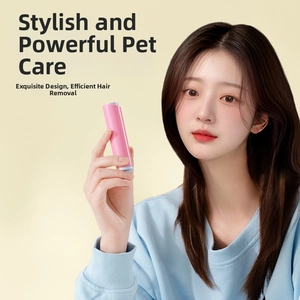 Pink portable lint roller with ergonomic handle shown in use by a hand on yellow background