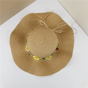 Détail du chapeau de paille avec fleurs au crochet et bord tissé ondulé