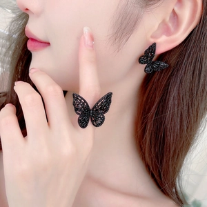 Detailed view of model wearing black butterfly rhinestone jewelry set with ring and earrings
