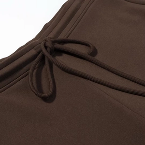 Détail du cordon de serrage et des coutures sur le pantalon évasé marron foncé