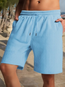 Detail view of light blue men's shorts showing knitted texture and drawstring waistband