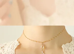 Close-up of golden butterfly choker with tassel zircon pendants on a model