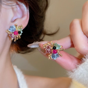 Detailed close-up of Monet style flower studs with colorful glass roses and gold branches