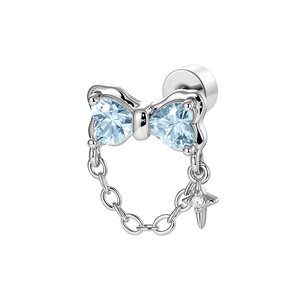 Silver bow ear cuff with light blue heart stones and hanging star chain on white background