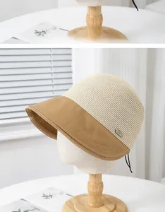 Detail of two-tone straw fisherman hat with a small metal Fashion tag on the side