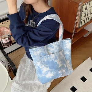 Dettaglio della borsa in tela tie-dye blu con tasca esterna e trama in tessuto resistente