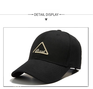 Detail view of black baseball cap with golden Break embroidery and triangle badge