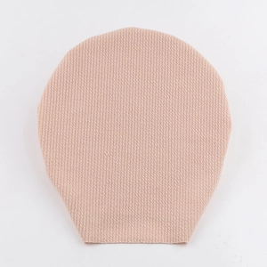 Close-up of teardrop-shaped nude knitted protective cover showing fine texture