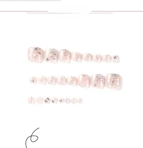 Detail shot of pink press-on toenails with glitter and silver butterfly sequins