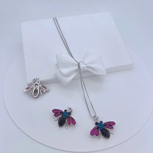 Detail view of bee pendants featuring pink, blue, and black zircons on an elegant gift box