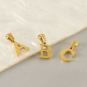 Three golden stainless steel letter A B C pendants displayed on a textured background