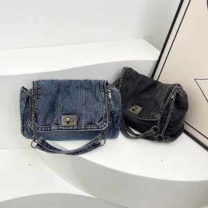 Blue and black denim tote bags with chain straps and metal twist locks on white background