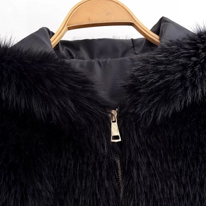 Women's black faux fur hooded jacket with gold zipper and plush texture on wooden hanger
