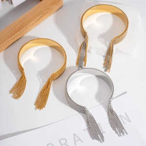 Détail des bracelets ouverts à pompons en or et argent avec perles métalliques fines