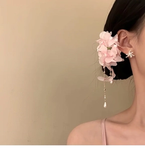 Detail of pink fabric flower hair clip with elegant pearl tassels on a model side