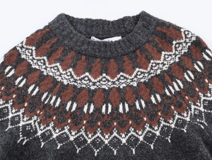 Detail of crew neck knitted sweater featuring brown and white geometric jacquard pattern
