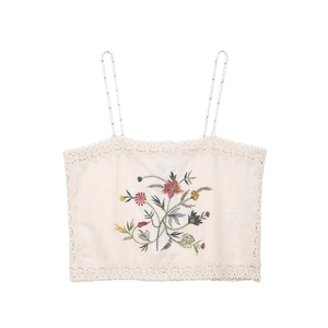 Flat lay of cream knit crop top with colorful floral embroidery and lace trim details