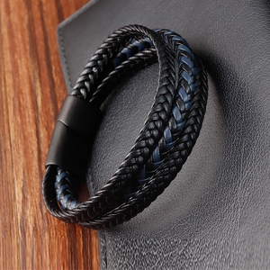 Mens black and blue braided leather bracelet with black magnetic clasp on wood