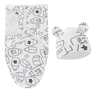 Detail of white cotton newborn swaddle and hat set with black milk carton patterns