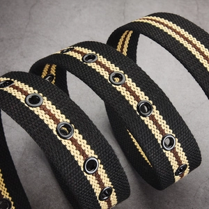 Classic black buckle canvas belt with beige and brown stripes on gray textured background
