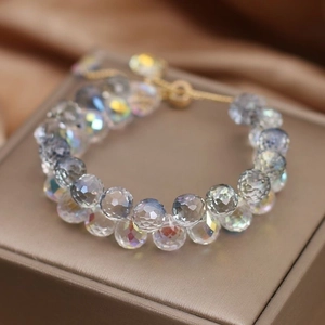 Close-up of clear aurora crystal beads on a bracelet with golden metal fastener