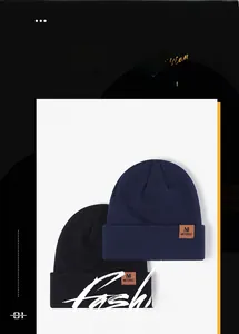 Detail showing the brown leather logo patch on ribbed navy and black winter beanies