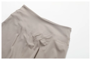 Close-up of high-waisted yoga leggings with V-shaped stitching in light taupe brushed fabric