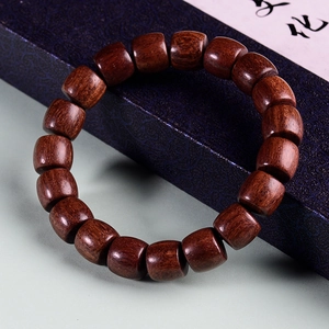 Vue détaillée de perles de santal en tonneau avec grain brillant sur écrin bleu
